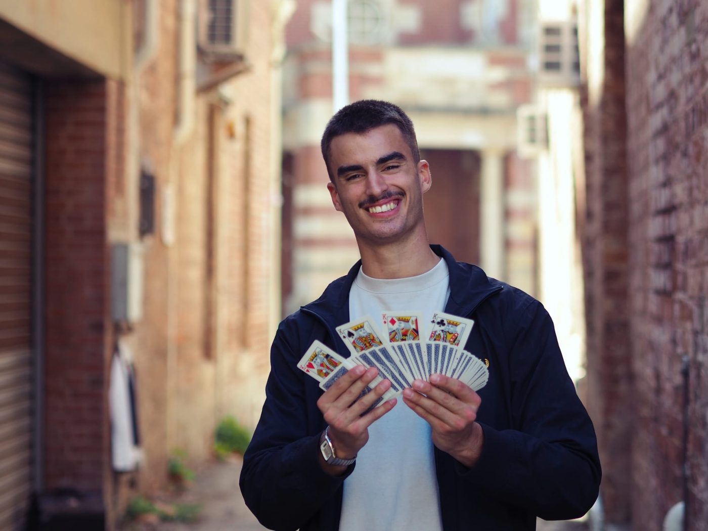 Dominic Miles holding a fan of four King cards