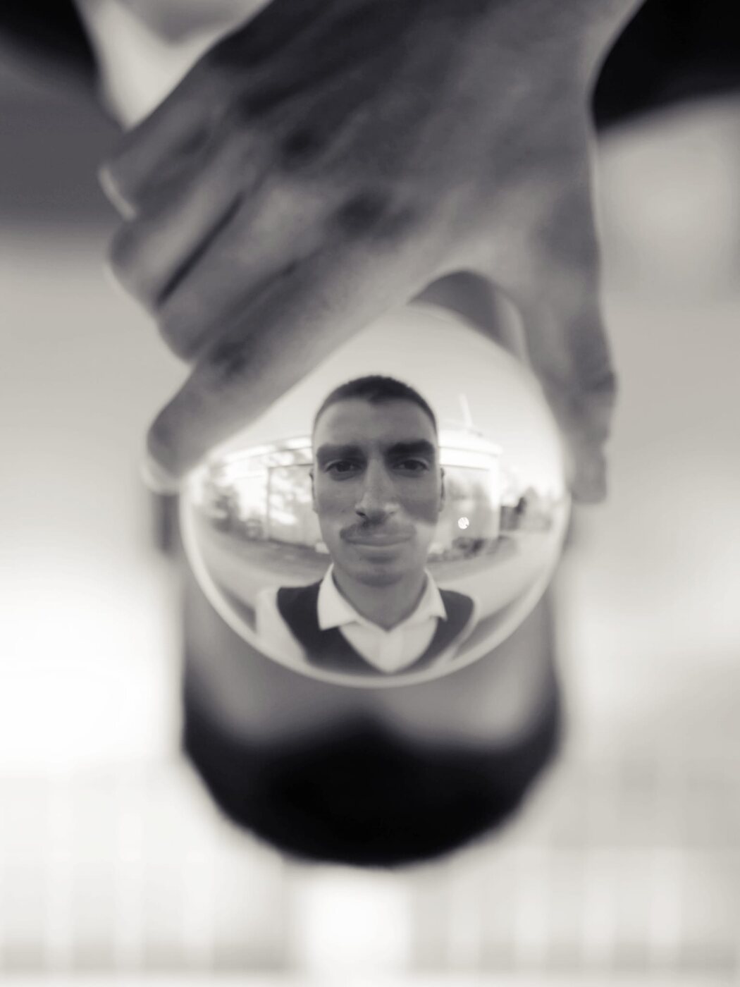 Black and white portrait of Dominic Miles reflected within a crystal ball