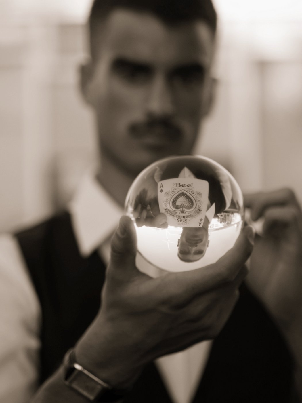 Dominic Miles holding a crystal ball with the Ace of Spades inside